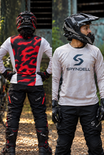 Load image into Gallery viewer, Sandstorm Elite Men’s Riding Jersey front and back view featuring a white and light grey camouflage design on the front with SPYNDELL branding and a bold red and black camouflage panel on the back, designed for motorcycle riders and riding enthusiasts.