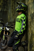 Load image into Gallery viewer, Green Vortex Men's Riding Jersey side view showing the green and black checkered sleeve graphics, breathable mesh fabric and athletic riding fit.
