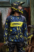 Load image into Gallery viewer, Neon Grunge Men's Riding Jersey in dark navy with neon yellow and blue grunge graphics, worn by a motocross rider with a dirt bike.

