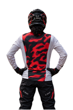 Load image into Gallery viewer, Sandstorm Elite Men's Riding Jersey in sand camouflage with contrasting orange-red sleeves and SPYNDELL branding, shown with a motorcycle rider.
